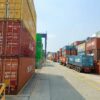 a long line of shipping containers on the side of a road
